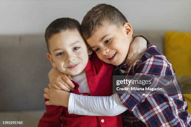 ritratto di due ragazzi sorridenti che si abbracciano - solo bambini maschi foto e immagini stock