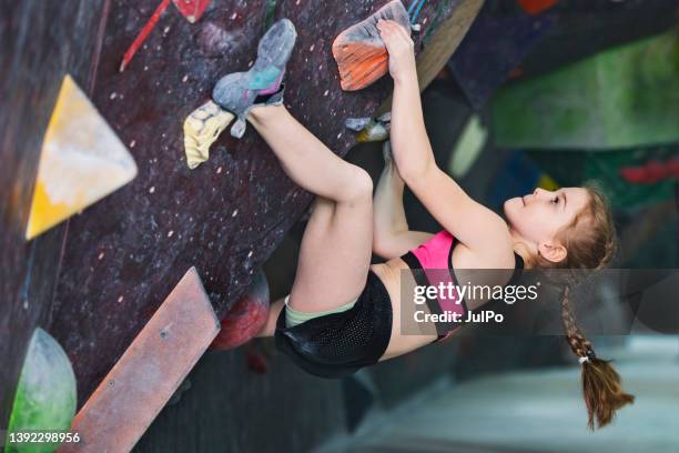 brave little girl climbing at rock-climbing wall - extreem weer stock pictures, royalty-free photos & images