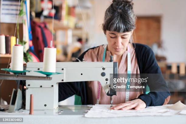 a tailor dressmaker in her studio. - woman sewing bildbanksfoton och bilder