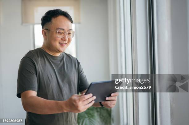 an asian male therapist using digital tablet on video call with an individual at home - online therapy stock pictures, royalty-free photos & images