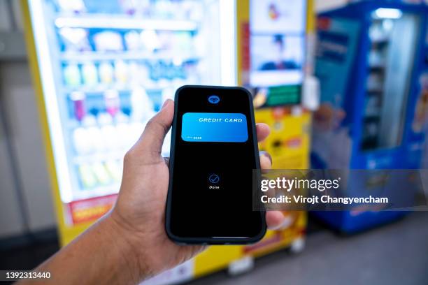 hands using mobile phone to pay purchase at the drinking vending machine - máquina de venda automática imagens e fotografias de stock