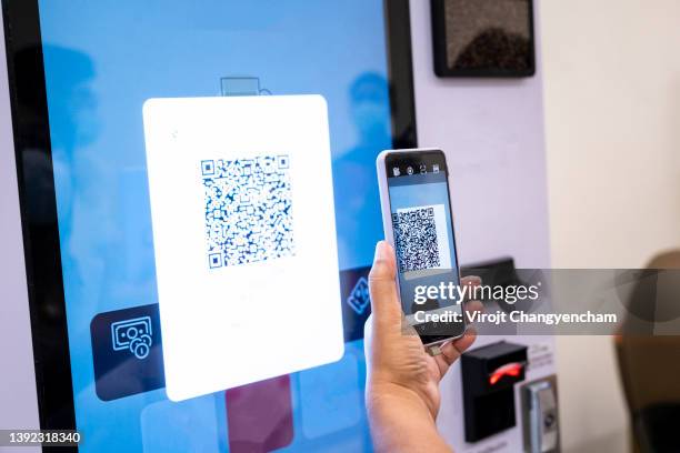 hands using mobile phone paying the soft drink at vending machine - qr stockfoto's en -beelden