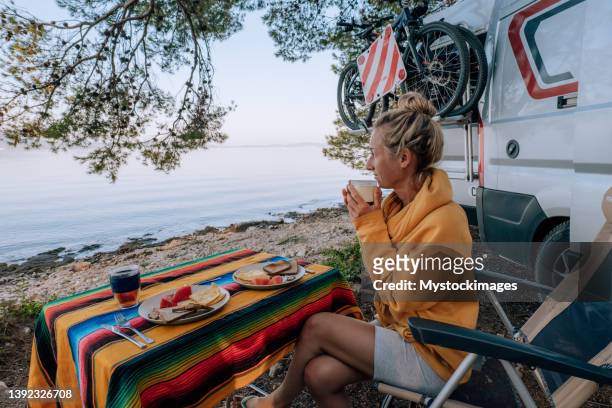 woman enjoys breakfast near her van, beach view - croatia tourist stock pictures, royalty-free photos & images