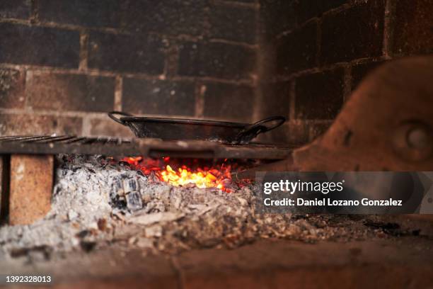 pan placed on grids in brick oven with burning fire - burning coal stock pictures, royalty-free photos & images