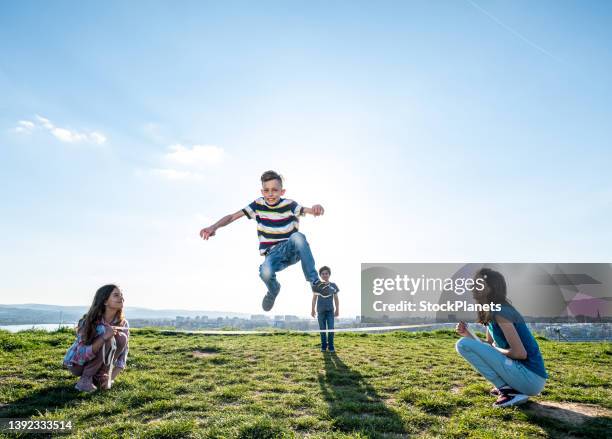 children playing jumping over rope - touwtje springen stockfoto's en -beelden