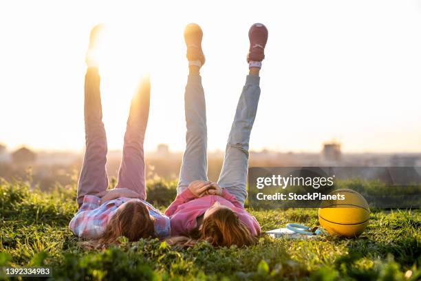 two girls are lying on the river bank - feet up stock pictures, royalty-free photos & images