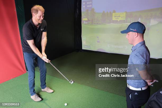 Prince Harry, Duke of Sussex gets a golf lesson by iSPS Handa ambassador Brendan Lawlor during day four of the Invictus Games The Hague 2020 at...