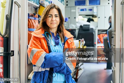 Portrait female paramedic in front of ambulance. Portrait female paramedic in front of ambulance.