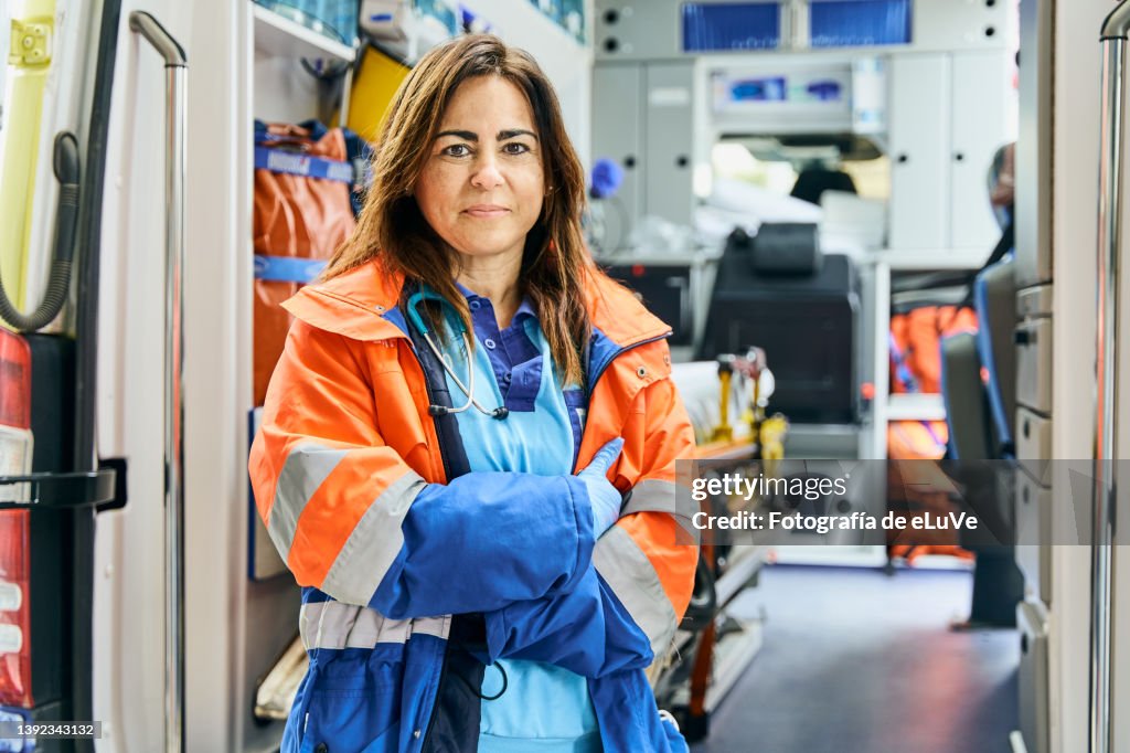 Portrait female paramedic in front of ambulance.