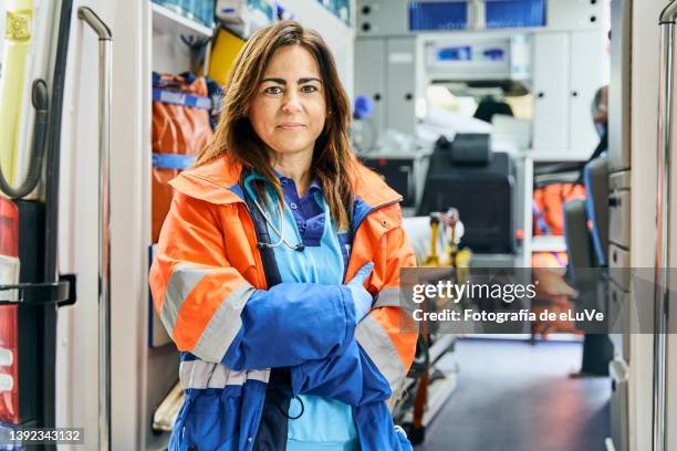 portrait female paramedic in front of ambulance. - paramedic - fotografias e filmes do acervo
