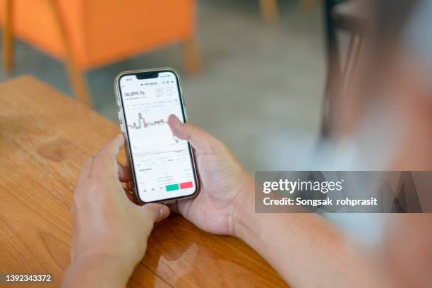 closeup - woman is checking bitcoin price chart on digital exchange on smartphone, cryptocurrency future price action prediction. - bitcoin phone stock pictures, royalty-free photos & images