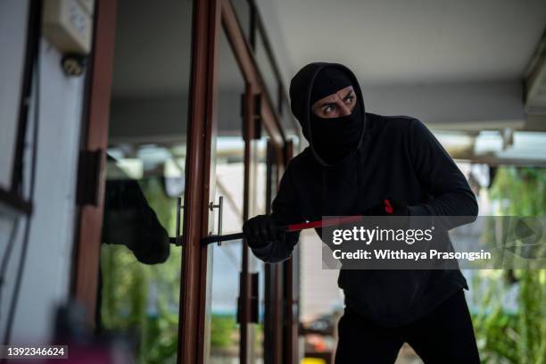 robber breaking in house - burgler stock-fotos und bilder