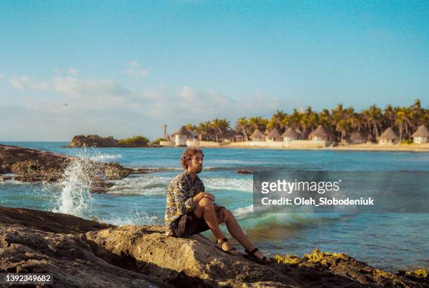 mann sitzt am strand in tulum - insel mujeres stock-fotos und bilder