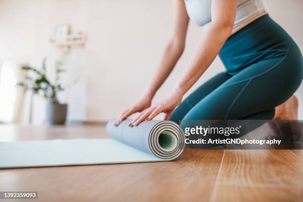 woman finishing up yoga practice. - finishing workout stock pictures, royalty-free photos & images