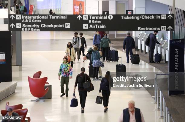 Airline passengers walk through San Francisco International Airport on April 19, 2022 in San Francisco, California. The Transportation Security...