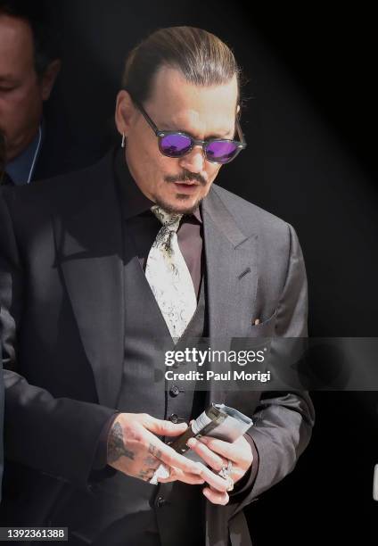 Johnny Depp steps outside court during the 8th day of his civil trial at Fairfax County Circuit Court on April 19, 2022 in Fairfax, Virginia. Depp is...