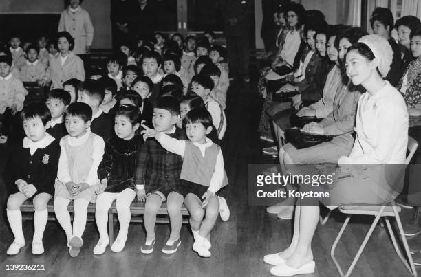 Prince Hiro, aka Prince Naruhito of Japan, watches a Doll Festival performance at Gakushuin Kindergarten in Tokyo, with his mother, Crown Princess...
