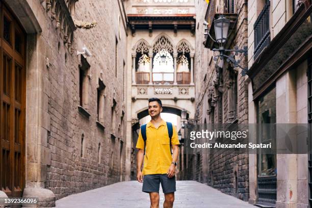 young happy smiling man walking in the streets of gothic quarter in barcelona, spain - mid volwassen mannen stockfoto's en -beelden