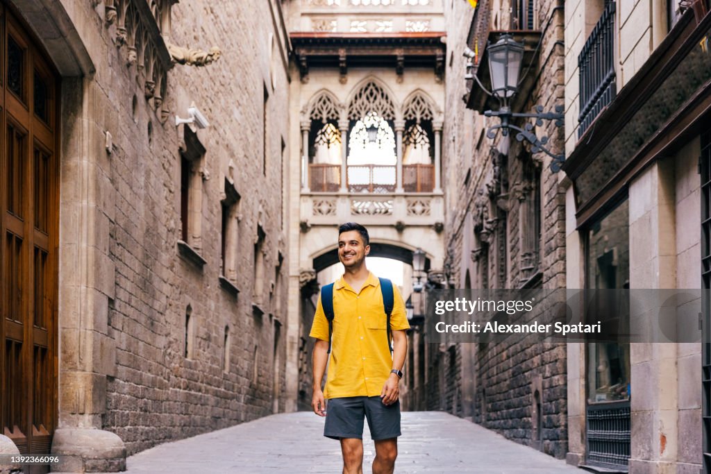 Young happy smiling man walking in the streets of Gothic Quarter in Barcelona, Spain