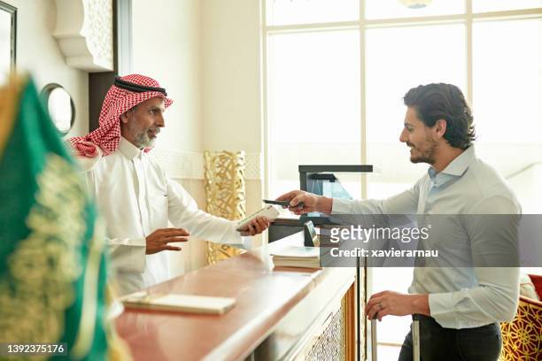 guest making contactless payment when checking out of hotel - ksa people stock pictures, royalty-free photos & images