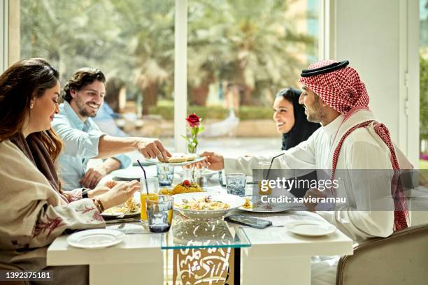 young saudi business professionals dining together - saudi lunch stock pictures, royalty-free photos & images