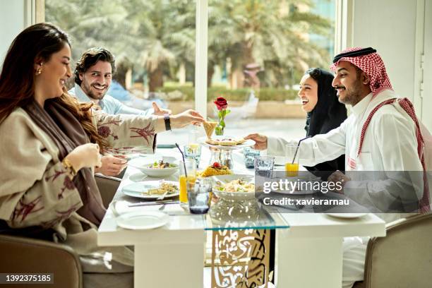 middle eastern associates enjoying business lunch together - saudi lunch stock pictures, royalty-free photos & images