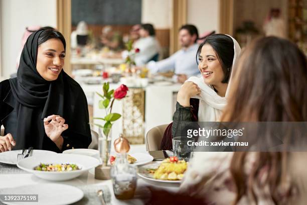 Riyadh mulheres na casa dos 20 anos sorrindo e falando durante o almoço