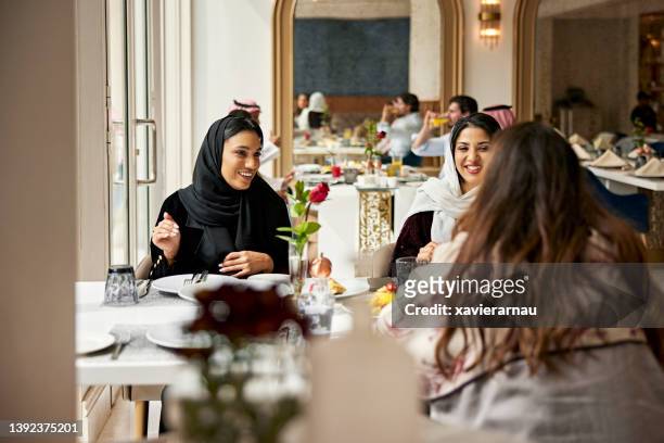 middle eastern women enjoying meal in hotel restaurant - saudi lunch stock pictures, royalty-free photos & images