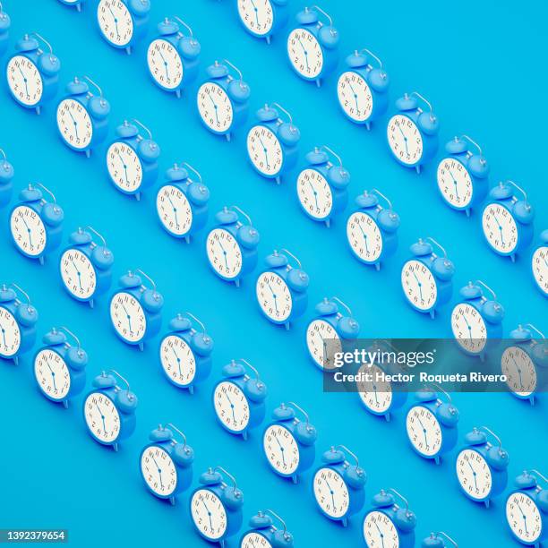 many blue alarm clock on blue background, 3d render - clock hand stock pictures, royalty-free photos & images