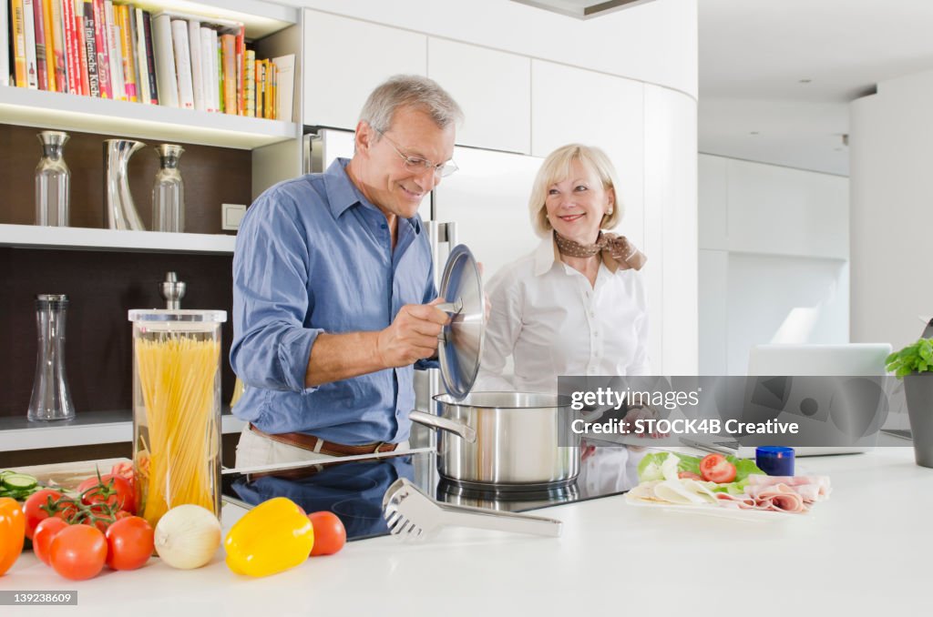 Senior couple preparing healthy pasta meal in kitchen