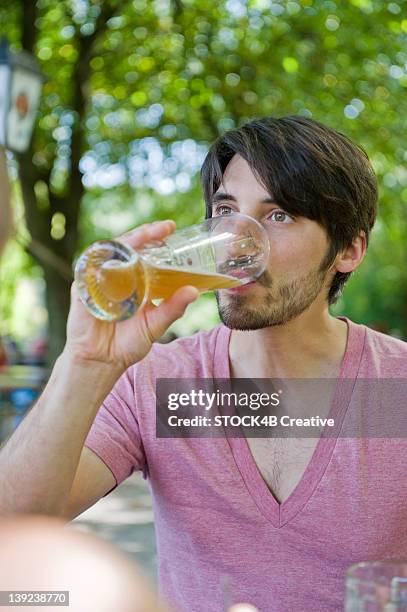 man drinking beer in beer garden - witbier stockfoto's en -beelden