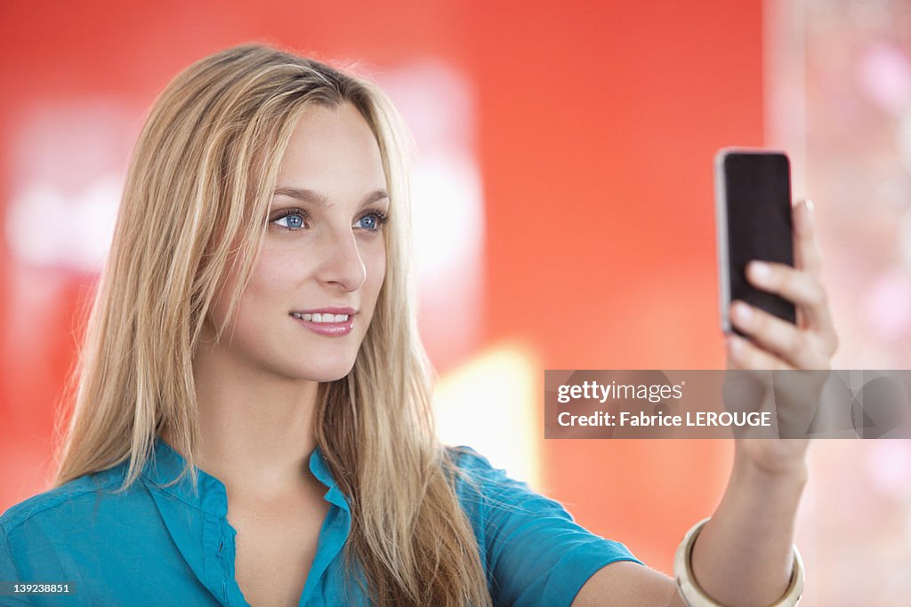 Young woman taking a picture of herself with a mobile phone