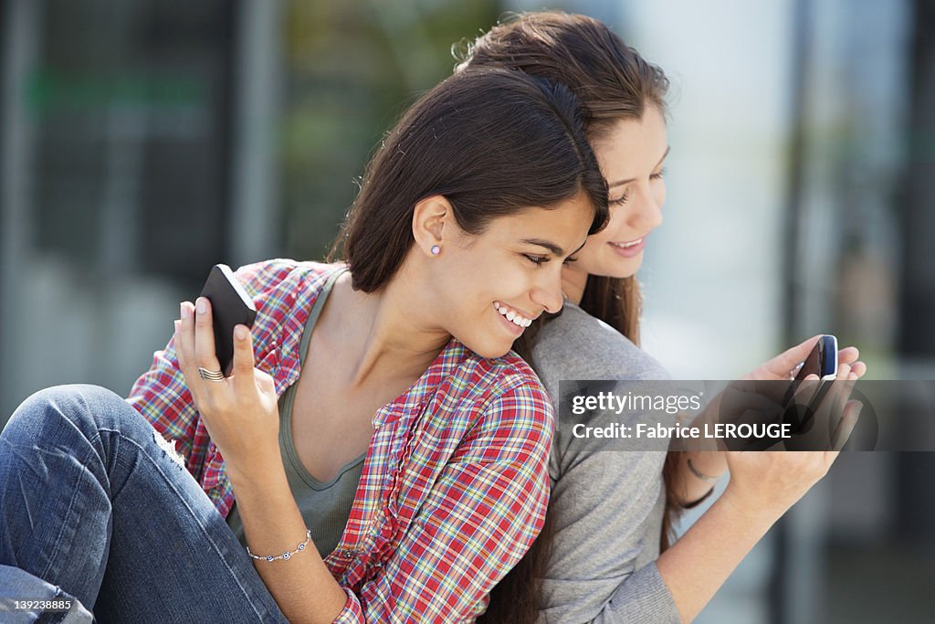 Young woman showing her message to her friend