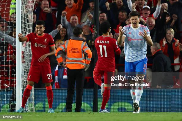 Harry Maguire of Manchester United reacts whilst Mohamed Salah of Liverpool celebrates scoring their side's second goal during the Premier League...