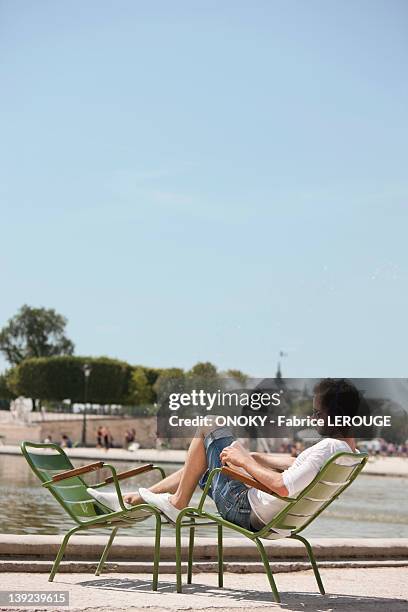 man sitting in a chair and reading a magazine, bassin octogonal, jardin des tuileries, paris, ile-de-france, france - jardin vertical stock pictures, royalty-free photos & images