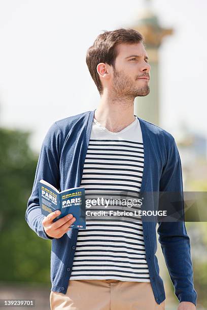 man holding a travel guidebook, paris, ile-de-france, france - rayas marineras fotografías e imágenes de stock