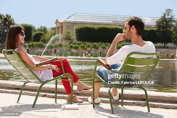 couple sitting in chairs near a pond in a garden, bassin octogonal, jardin des tuileries, paris, ile-de-france, france - chaise de dos photos et images de collection