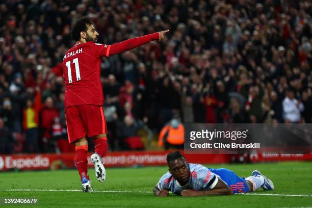Mohamed Salah of Liverpool celebrates scoring their side's fourth goal as Aaron Wan-Bissaka of Manchester United reacts during the Premier League...