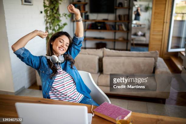 a young woman is resting during a break from a video call - breaking and exiting stockfoto's en -beelden