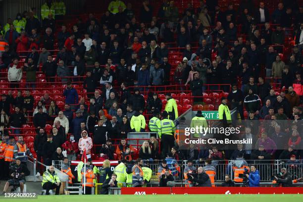 General view of empty seats in the away end before full time, as fans of Manchester United look on during the Premier League match between Liverpool...