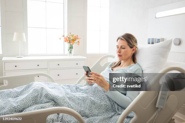 mid adult woman in hospital. - beautiful women bed stockfoto's en -beelden