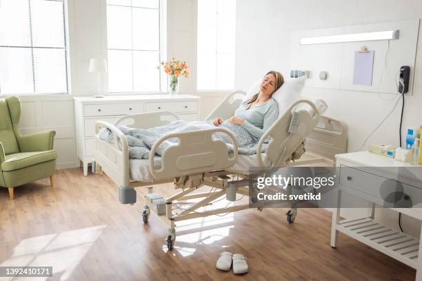 mittlere erwachsene frau im krankenhaus. - krankenbett stock-fotos und bilder