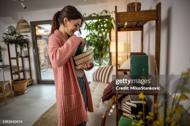 women arranging stuff in new apartmen - woman arranging stock pictures, royalty-free photos & images