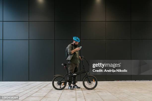 male commuter using mobile phone - e bike stock pictures, royalty-free photos & images