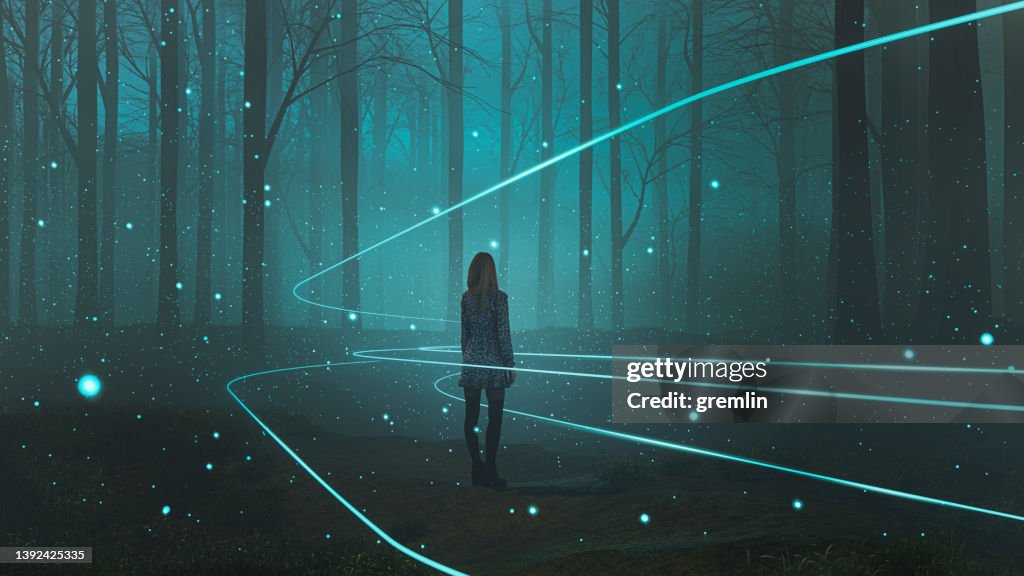 Woman standing in forest with mysterious lights
