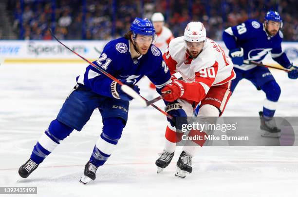 Brayden Point of the Tampa Bay Lightning and Joe Veleno of the Detroit Red Wings fight for the puck in the second period during a game at Amalie...