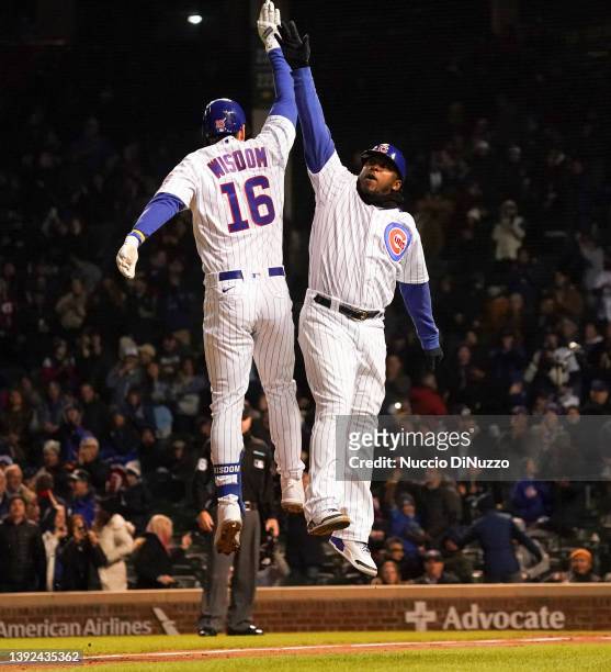 Patrick Wisdom of the Chicago Cubs celebrates with third base coach Willie Harris following Wisdom's two-run home run during the fourth inning...
