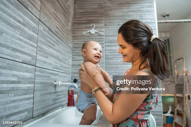 baby bath time - mother and baby taking a bath stock pictures, royalty-free photos & images