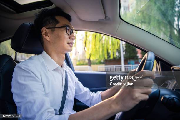 man driving his car - asian man car stock pictures, royalty-free photos & images