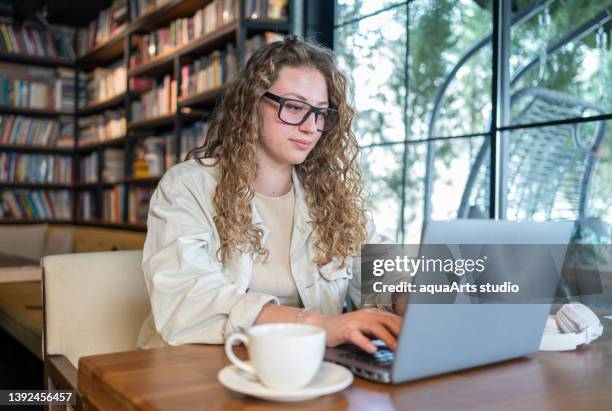young beautiful woman works i̇n a cafe - bookstore cafe stock pictures, royalty-free photos & images